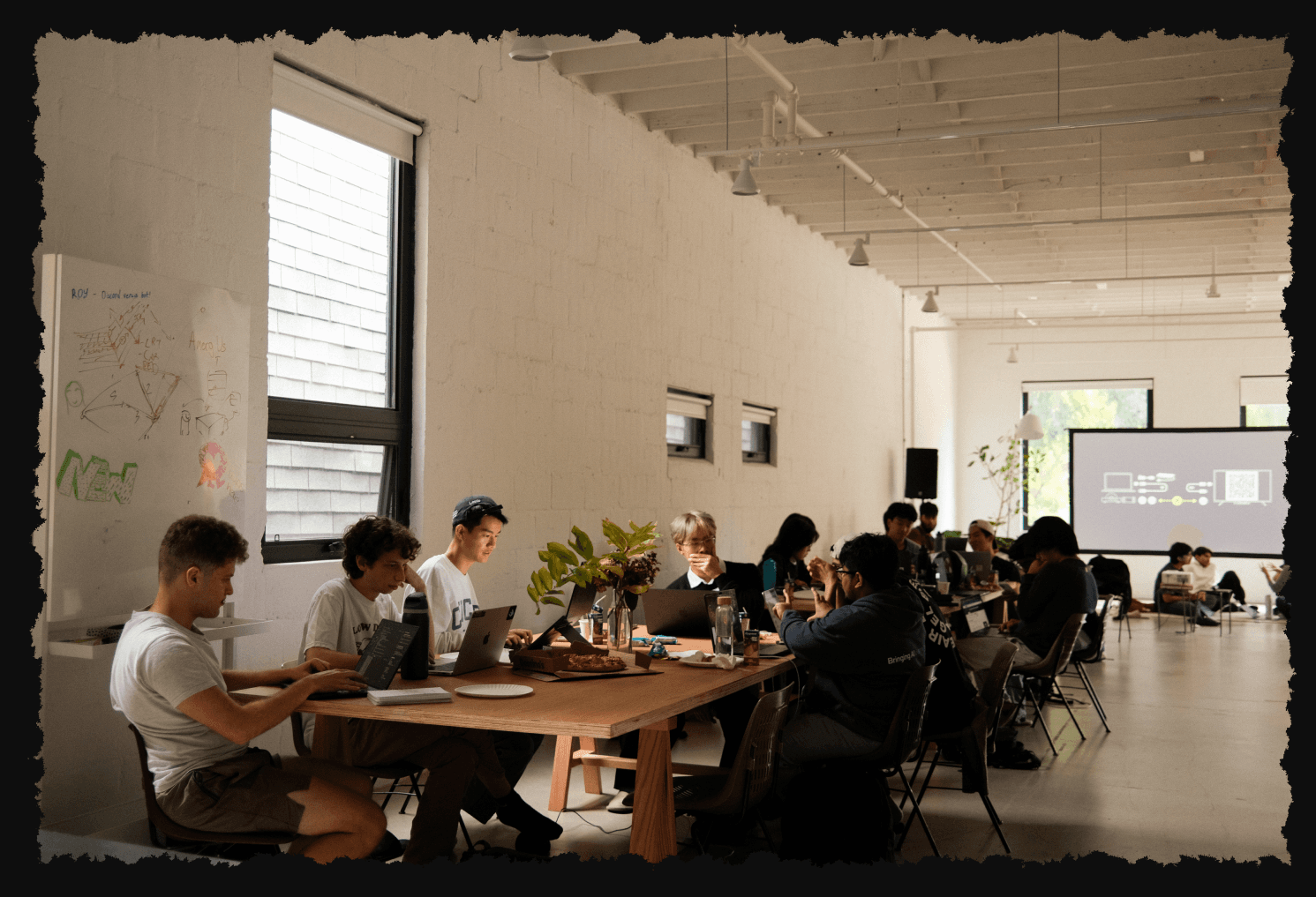 hackathon participants working together at a long table